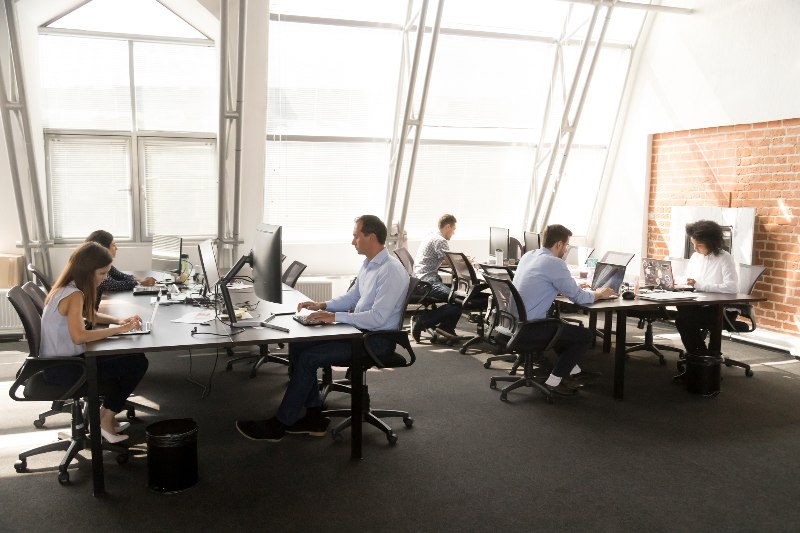 People working at shared desks in office by Urban Office