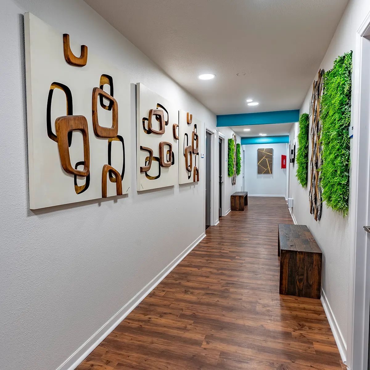 Hallway with wood floors and art on the walls, creating a warm and inviting atmosphere in Texas